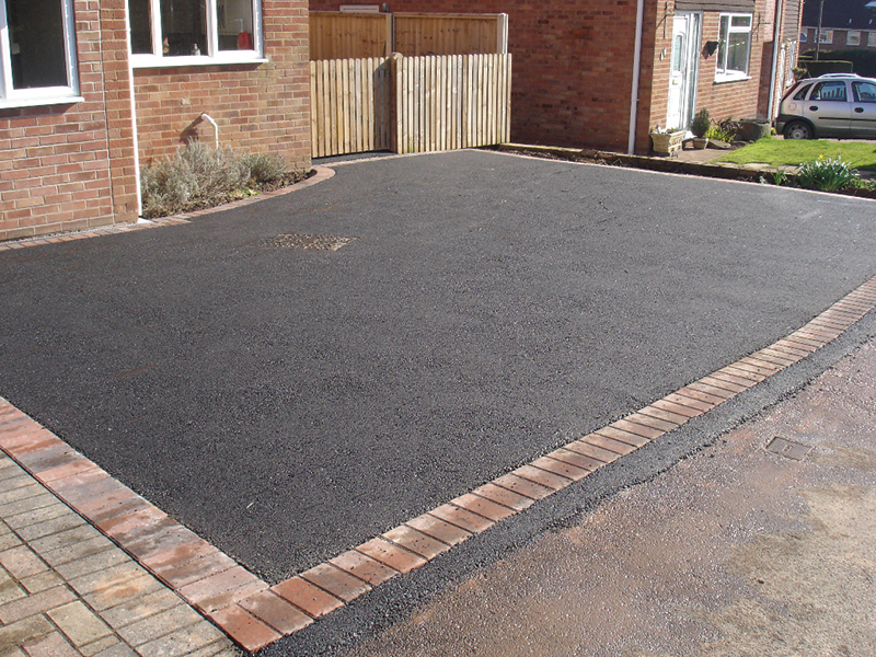 Tarmac driveway image with a clean dark surface and kerb edging.